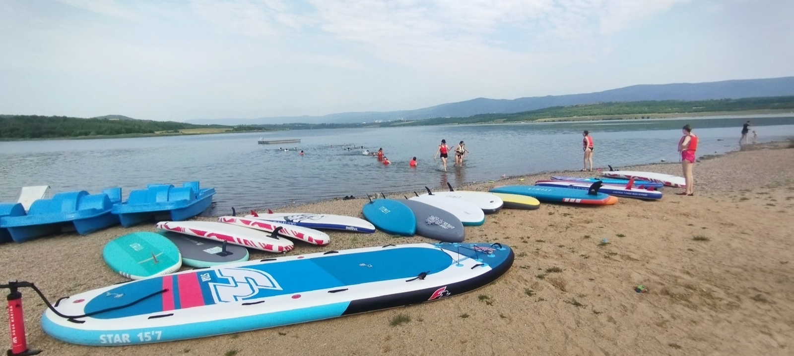 Paddleboardy připravené na břehu jezera Milada